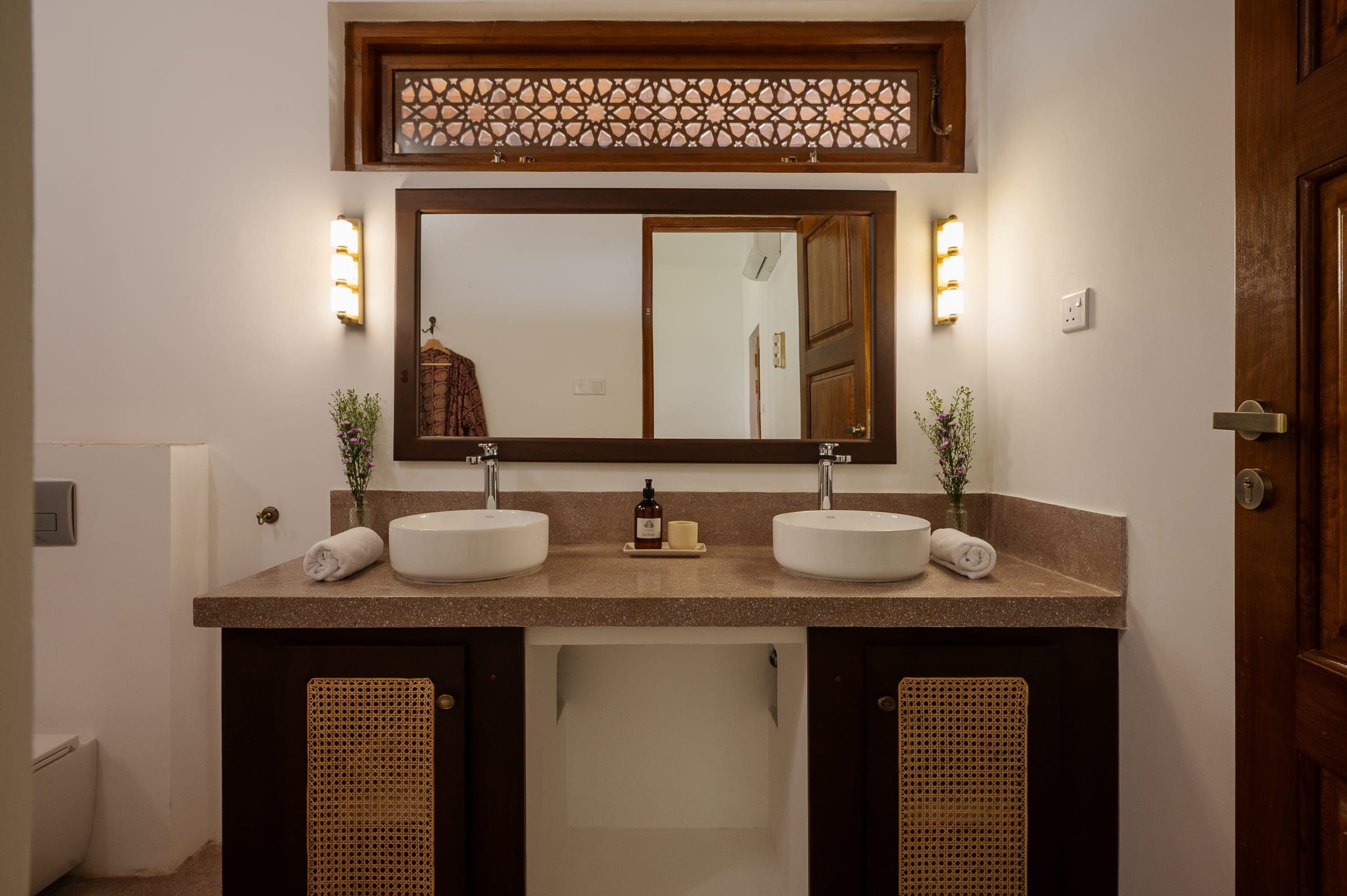 An ensuite bathroom at Kottamba Kanda with a double vanity, twin basins and cane-fronted cabinets