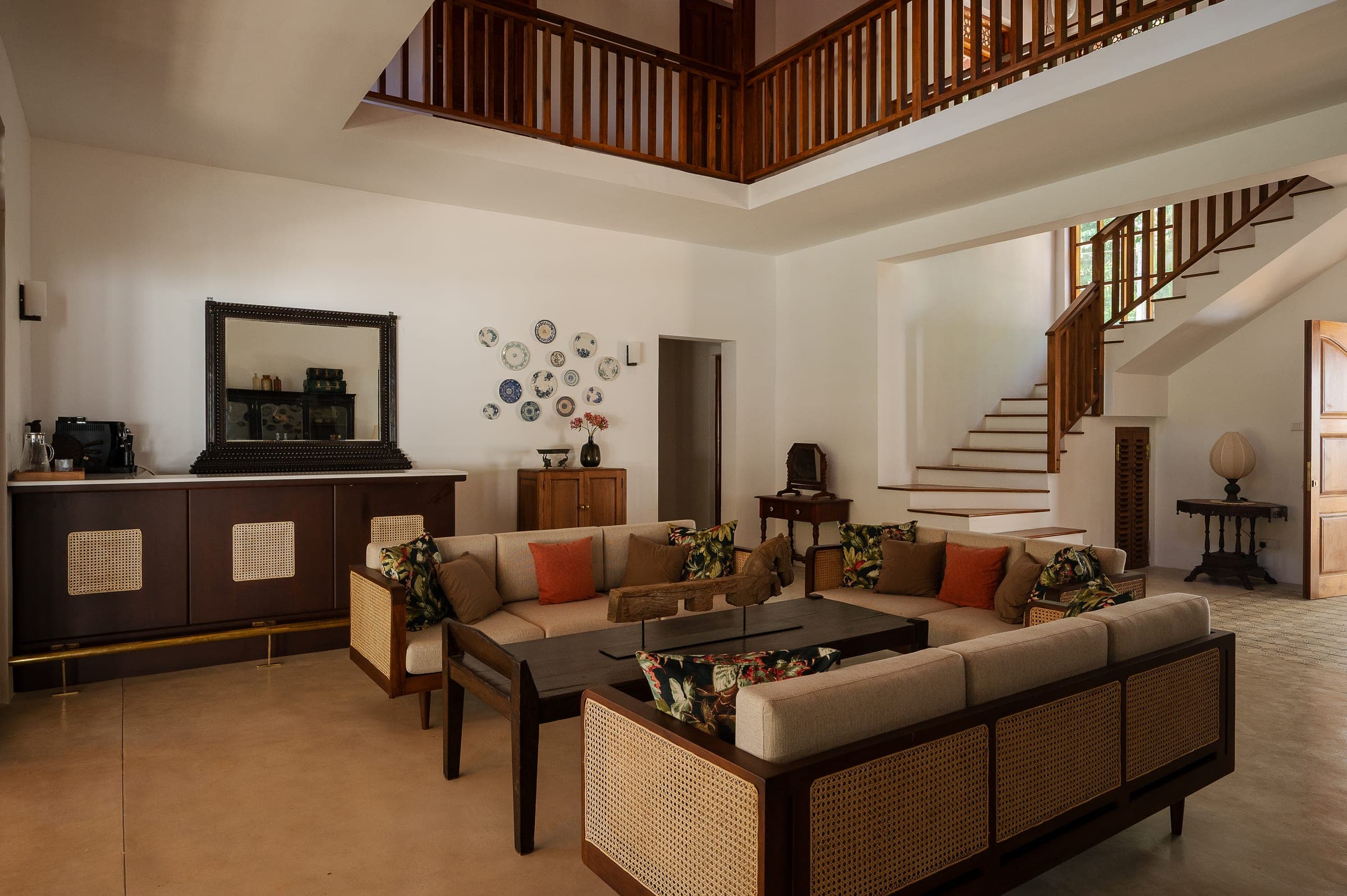 The living room and bar at Kottamba Kanda, the teak staircase rising behind the sofas