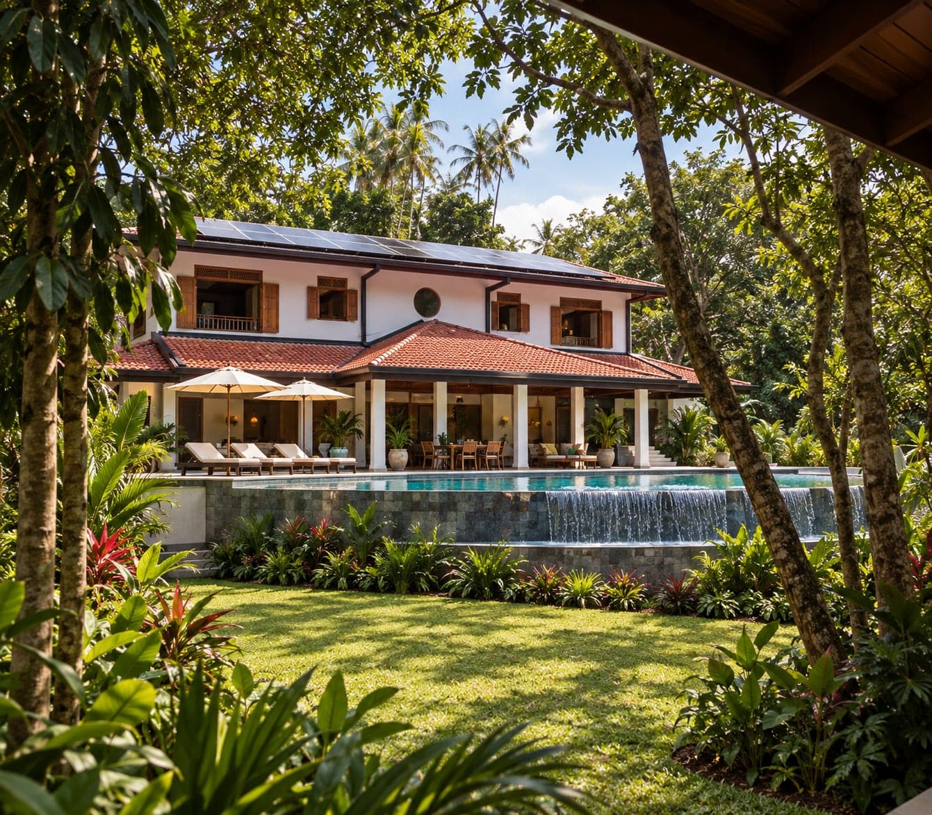 The villa seen through the garden trees, its infinity pool spilling over the wall to the lower lawn (architectural render)